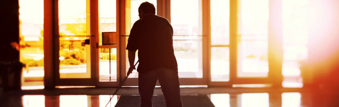 male janitor mopping floors of entry of office building