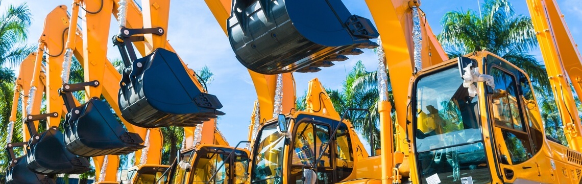 How automation can turn tax compliance into a competitive edge for heavy equipment dealers A row of yellow excavators parked at a heavy equipment dealer lot.