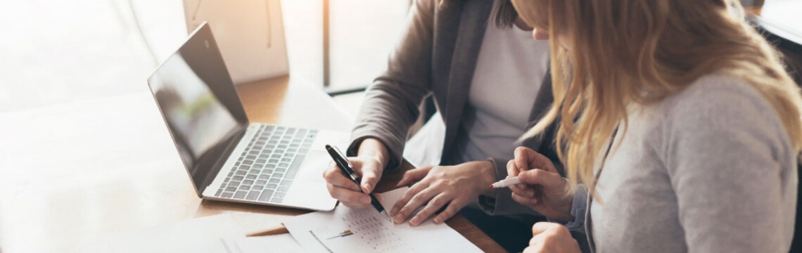 Two women working together at an office desk