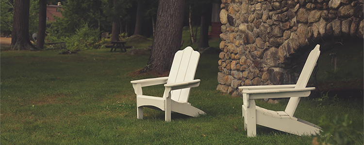 Backyard with two white Adirondack chairs