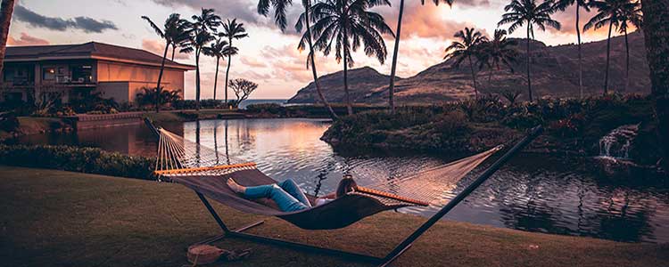 Woman lying in sunset enjoying Hawaii sunset