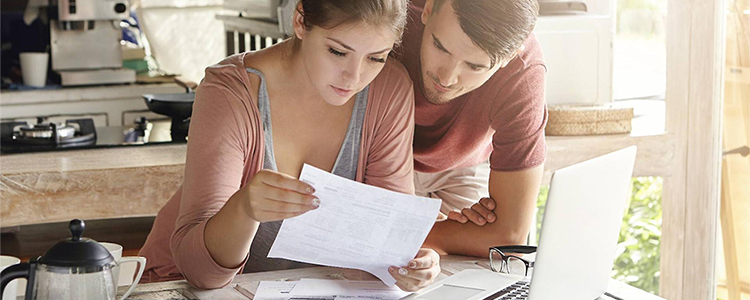 woman and man looking over forms and laptop