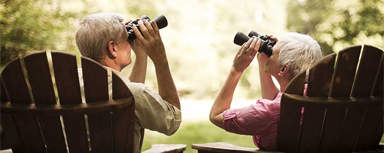 Mature couple birdwatching with binoculars
