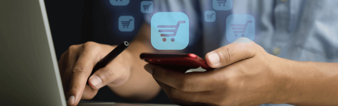 person using laptop and holding mobile phone, with graphics representing online commerce