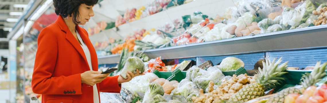 Woman in a grocery store shopping for vegetables.