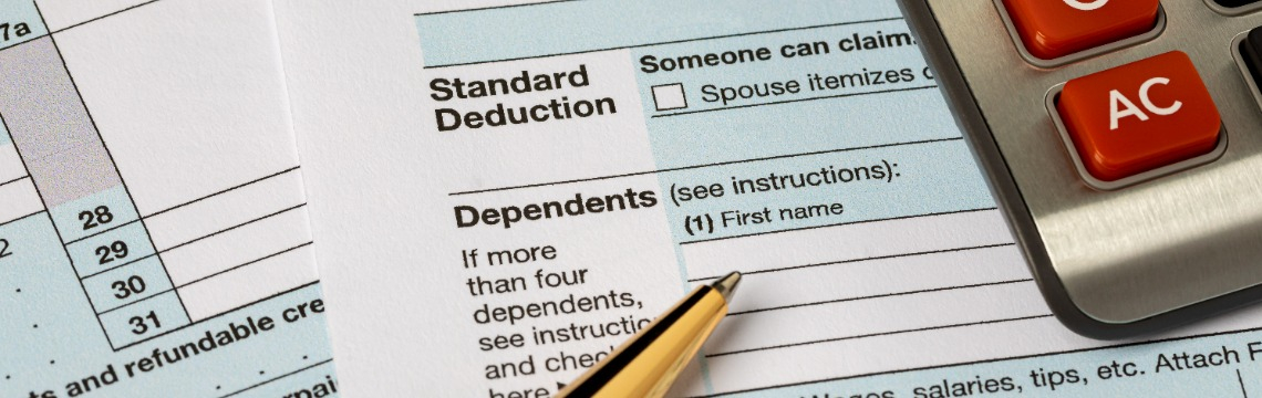 standard-deduction-tax-form IRS form featuring the standard deduction, with a pen and a calculator.
